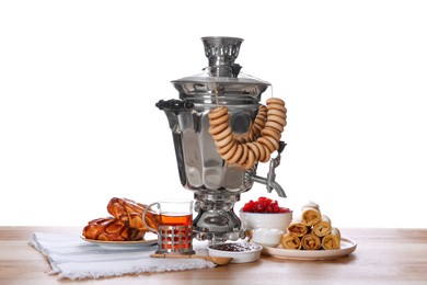 Traditional Russian samovar and treats on wooden table against white background