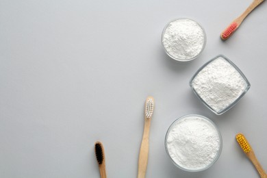 Tooth powder and brushes on white background, flat lay. Space for text