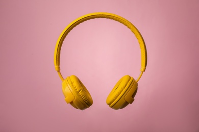 Photo of Wireless headphones with earmuffs on color background