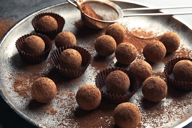 Plate with tasty chocolate truffles on table