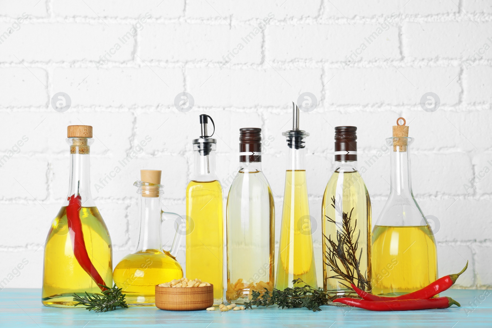 Photo of Different cooking oils on blue wooden table