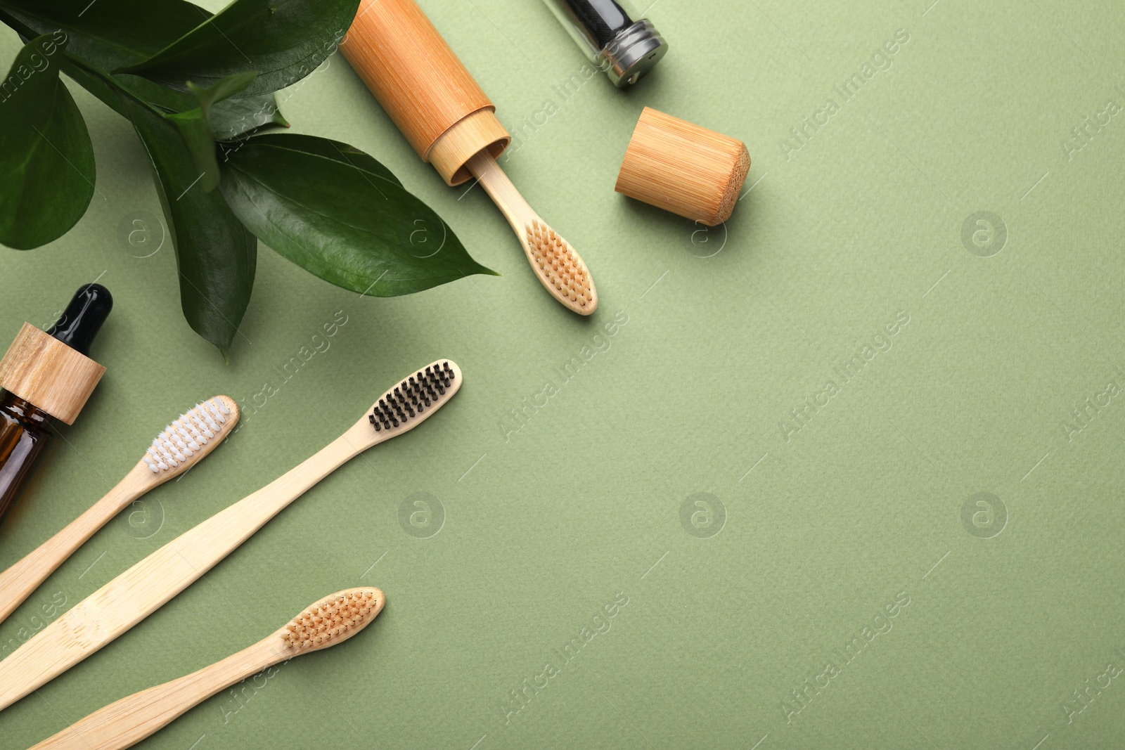 Photo of Flat lay composition with bamboo toothbrushes on green background, space for text