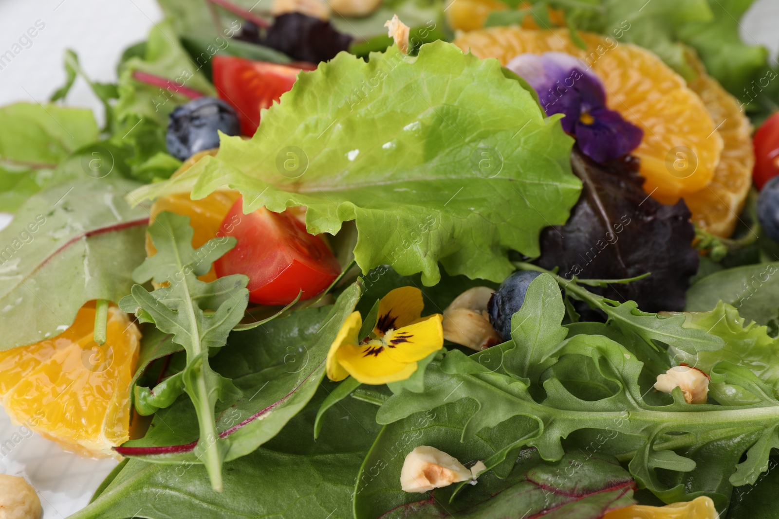 Photo of Delicious salad with tomatoes and orange slices, closeup