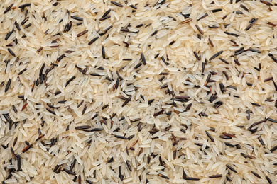 Photo of Mix of different brown and polished rice as background, top view