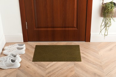 Clean door mat on wooden floor in hall