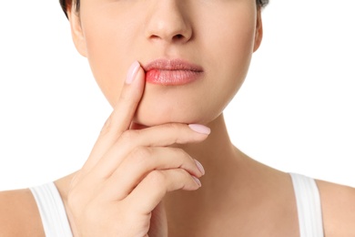 Photo of Woman with cold sore touching lips on white background, closeup