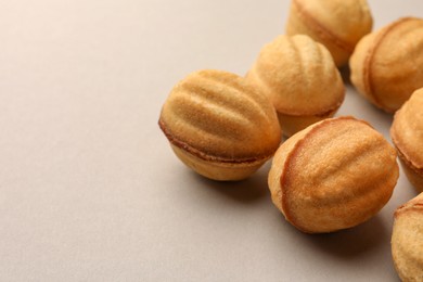 Photo of Homemade walnut shaped cookies with condensed milk on light grey background, closeup. Space for text