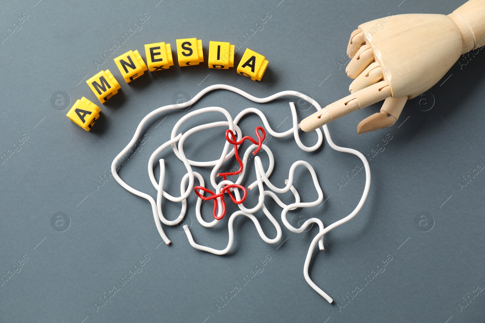 Photo of Word Amnesia, brain made of wires and mannequin hand on grey background, flat lay