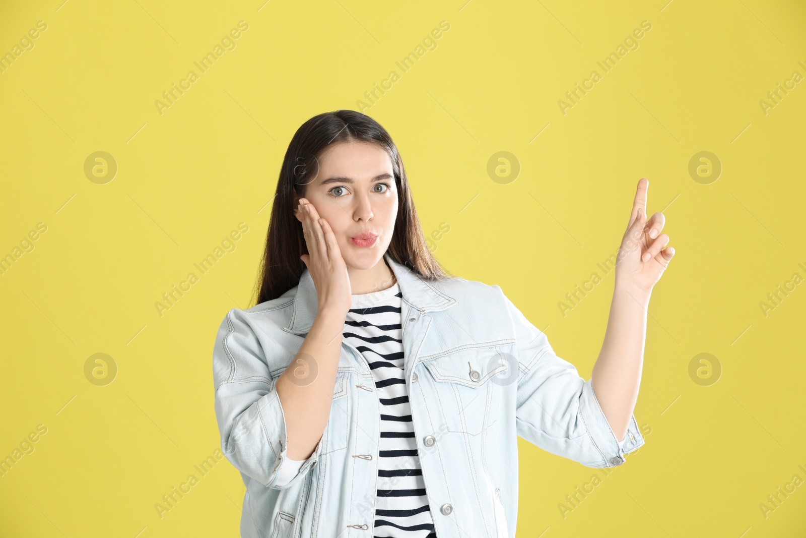Photo of Portrait of young emotional young woman on yellow background