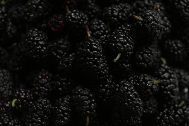 Photo of Heap of delicious ripe black mulberries as background, closeup