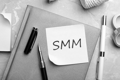 Image of Note with abbreviation SMM and stationery on table, flat lay. Social media marketing