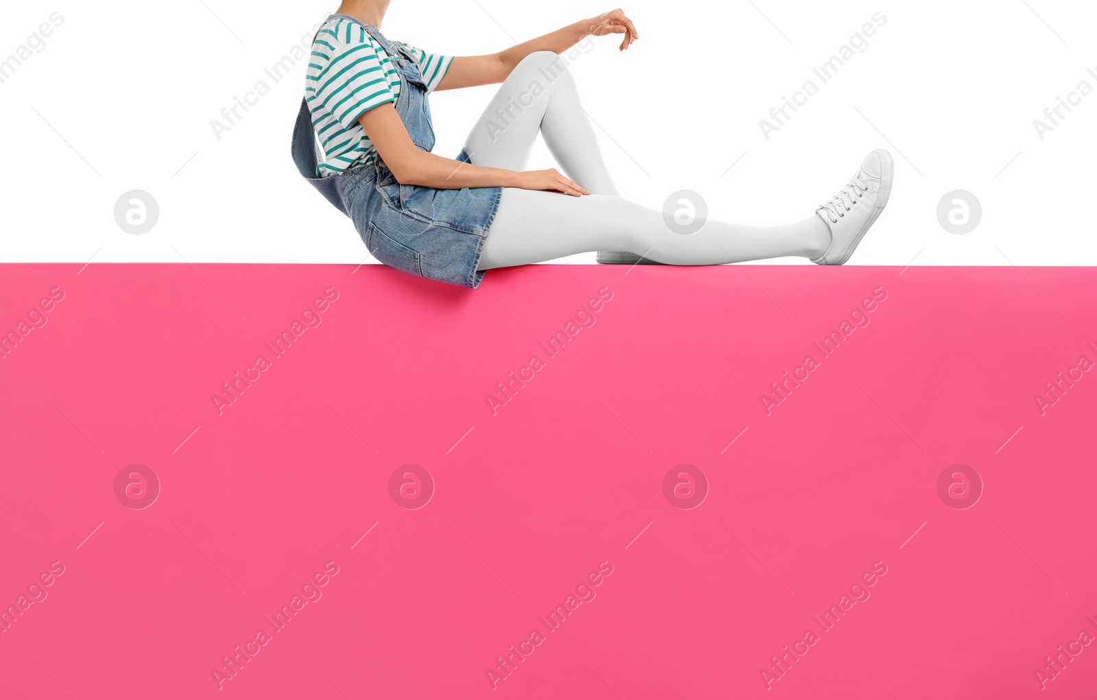 Photo of Woman wearing white tights and stylish shoes sitting on color background, closeup