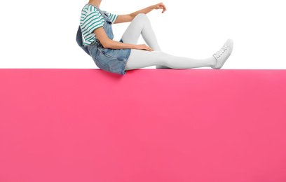 Photo of Woman wearing white tights and stylish shoes sitting on color background, closeup