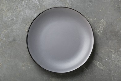 Photo of Empty ceramic plate on grey table, top view