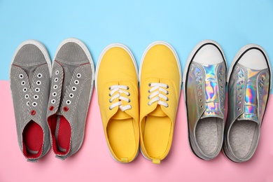 Photo of Modern trendy sneakers on color background, top view