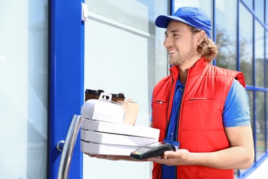 Male courier with terminal delivering food to door