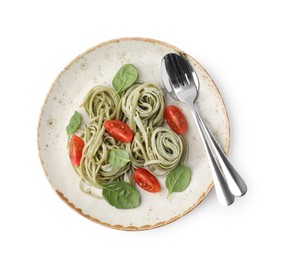 Photo of Tasty pasta with spinach, tomatoes and cutlery isolated on white, top view