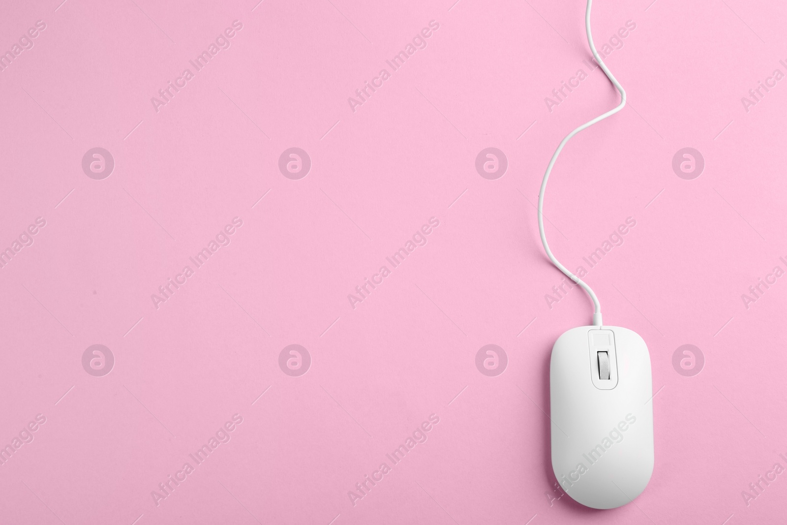 Photo of Modern wired optical mouse on pink background, top view. Space for text