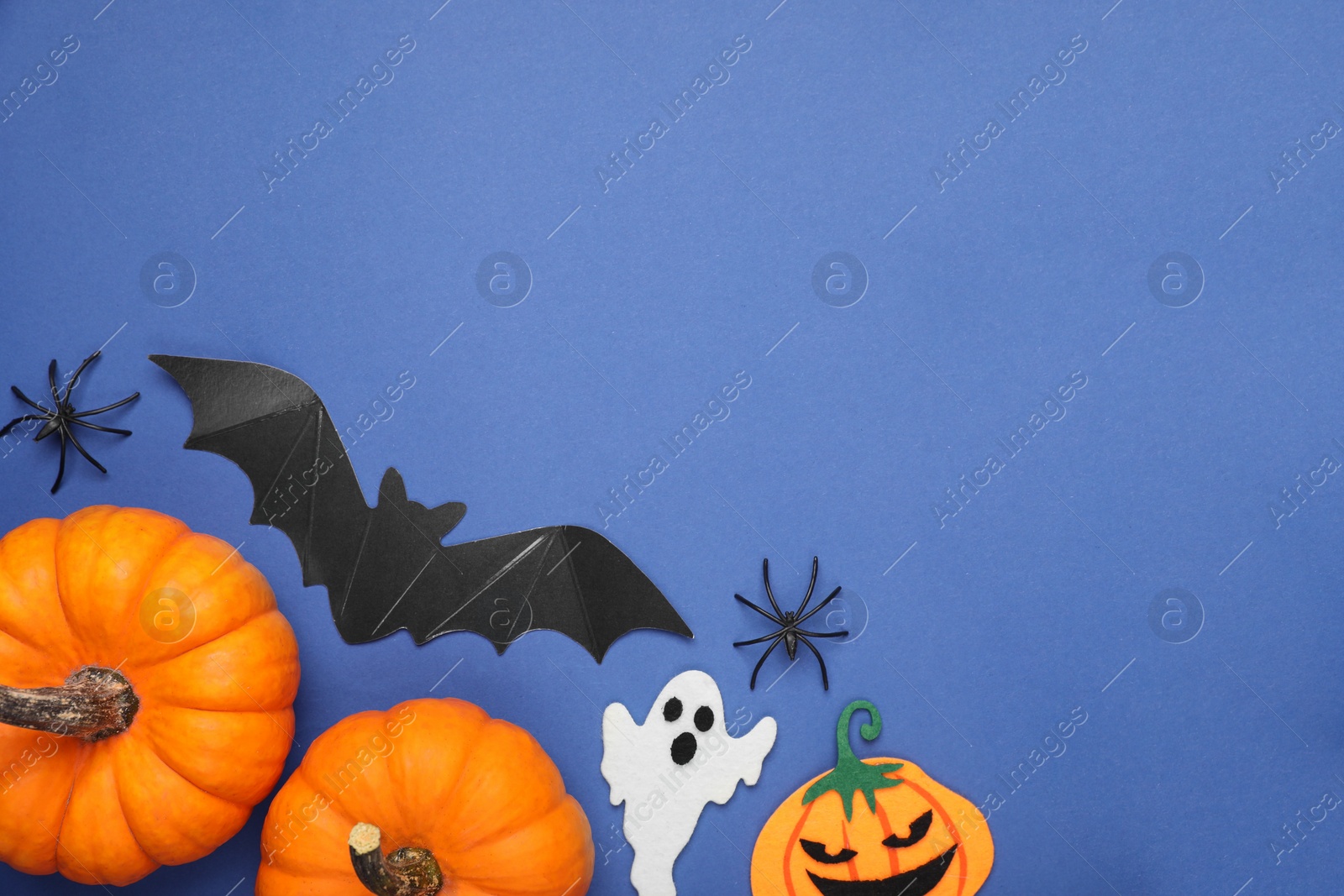 Photo of Flat lay composition with Halloween decor on blue background, space for text