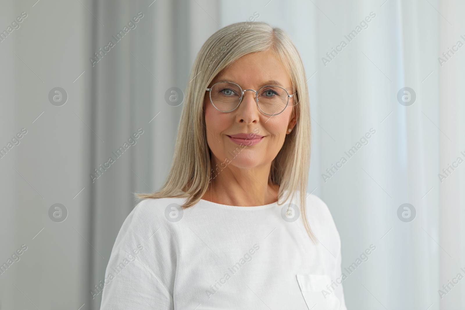 Photo of Portrait of beautiful middle aged woman in eyeglasses indoors