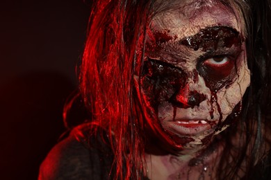 Photo of Scary zombie on dark background, closeup. Halloween monster