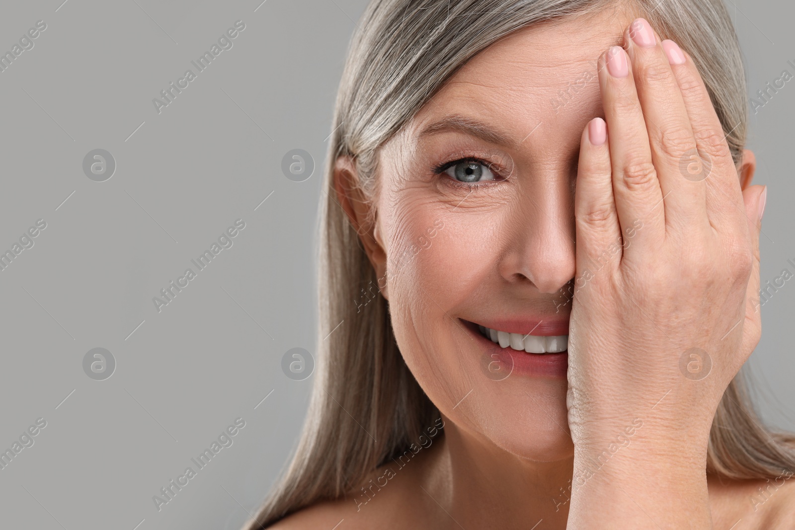 Photo of Beautiful mature woman with healthy skin on gray background, space for text