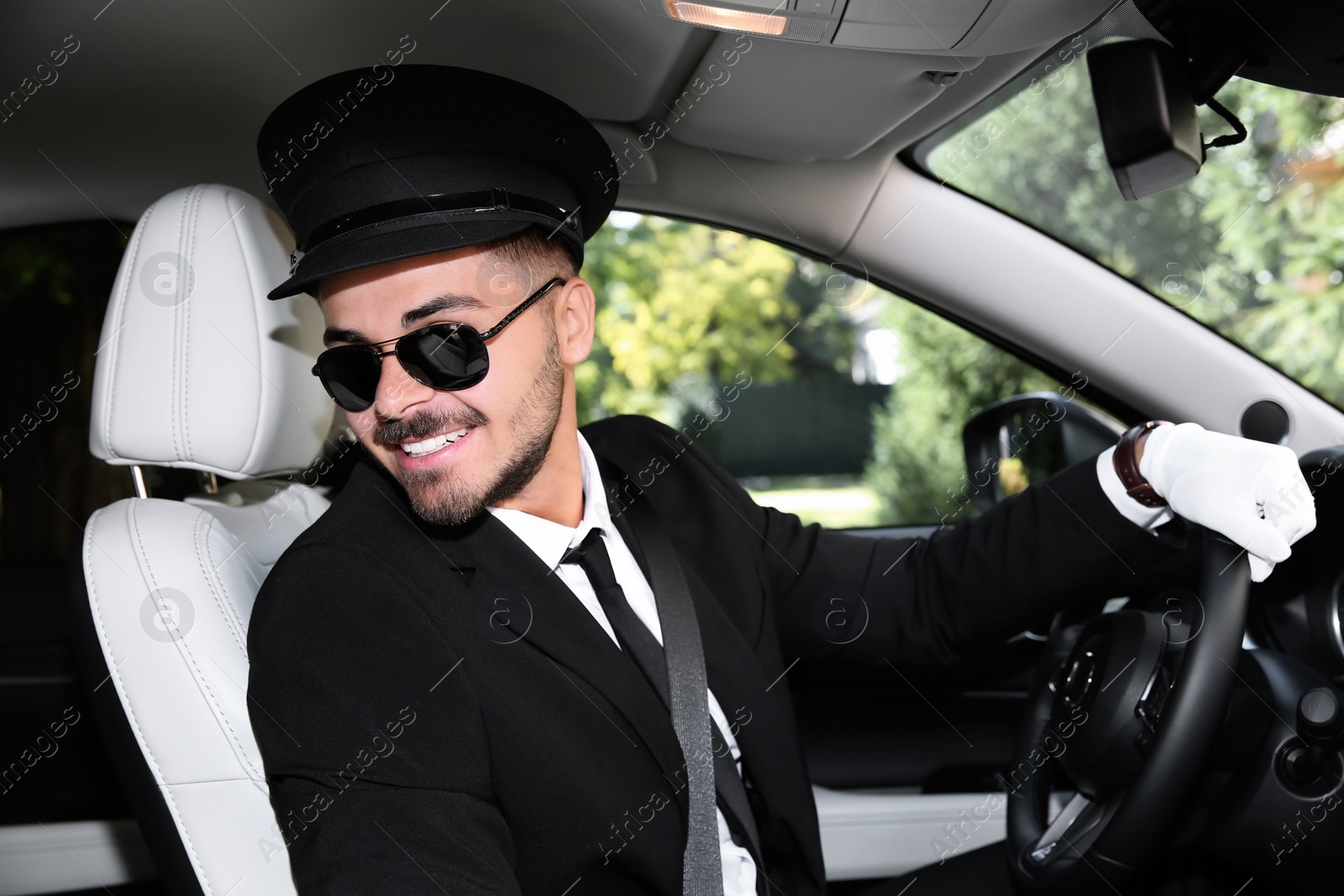 Photo of Young handsome driver in luxury car. Chauffeur service