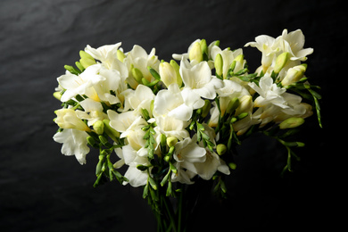 Photo of Beautiful freesia flowers on black background, closeup