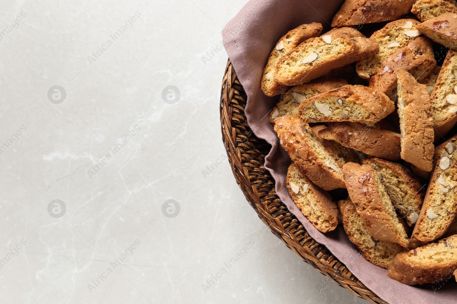 Photo of Traditional Italian almond biscuits (Cantucci) on light table, top view. Space for text