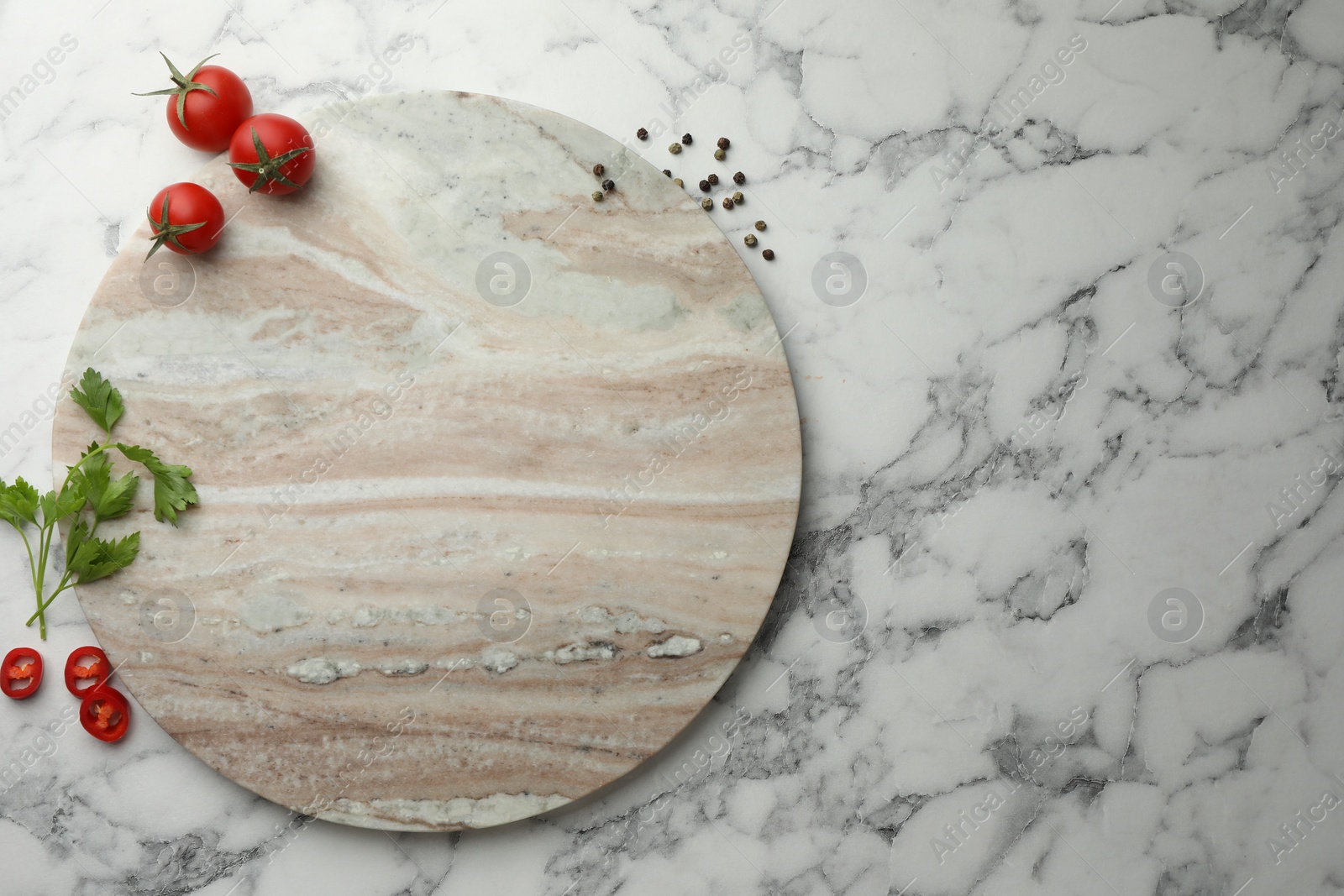 Photo of Cutting board, parsley, pepper and tomatoes on white marble table, flat lay. Space for text