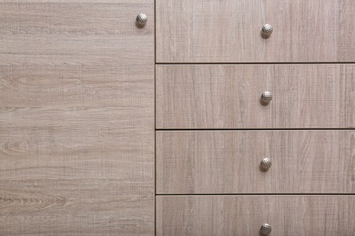 Photo of Wooden wardrobe drawers as background, closeup view