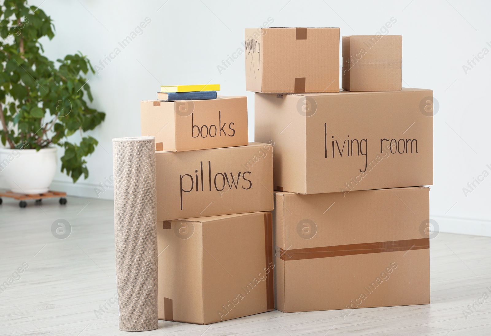 Photo of Cardboard boxes and household stuff indoors. Moving day