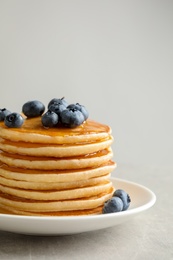 Photo of Plate with pancakes and berries on grey background, closeup