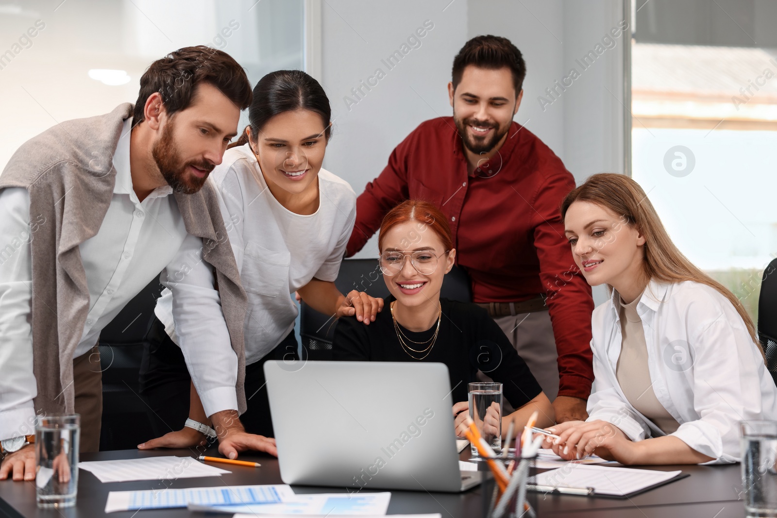 Photo of Team of employees working together in office