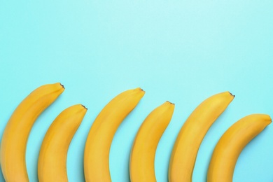 Ripe tasty bananas on blue background, flat lay