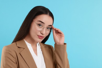 Photo of Beautiful woman wearing glasses on turquoise background, space for text