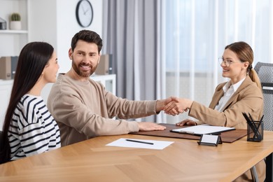 Lawyer shaking hands with clients in office