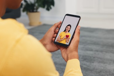 Image of Long distance love. Man having video chat with his girlfriend via smartphone at home, closeup