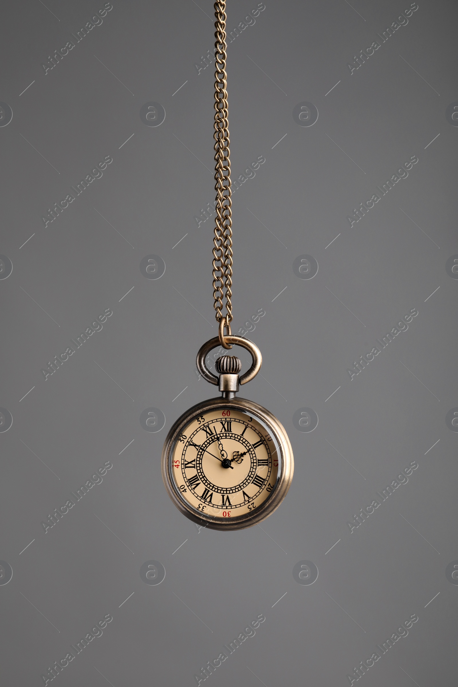 Photo of Stylish pendulum on grey background. Hypnotherapy session