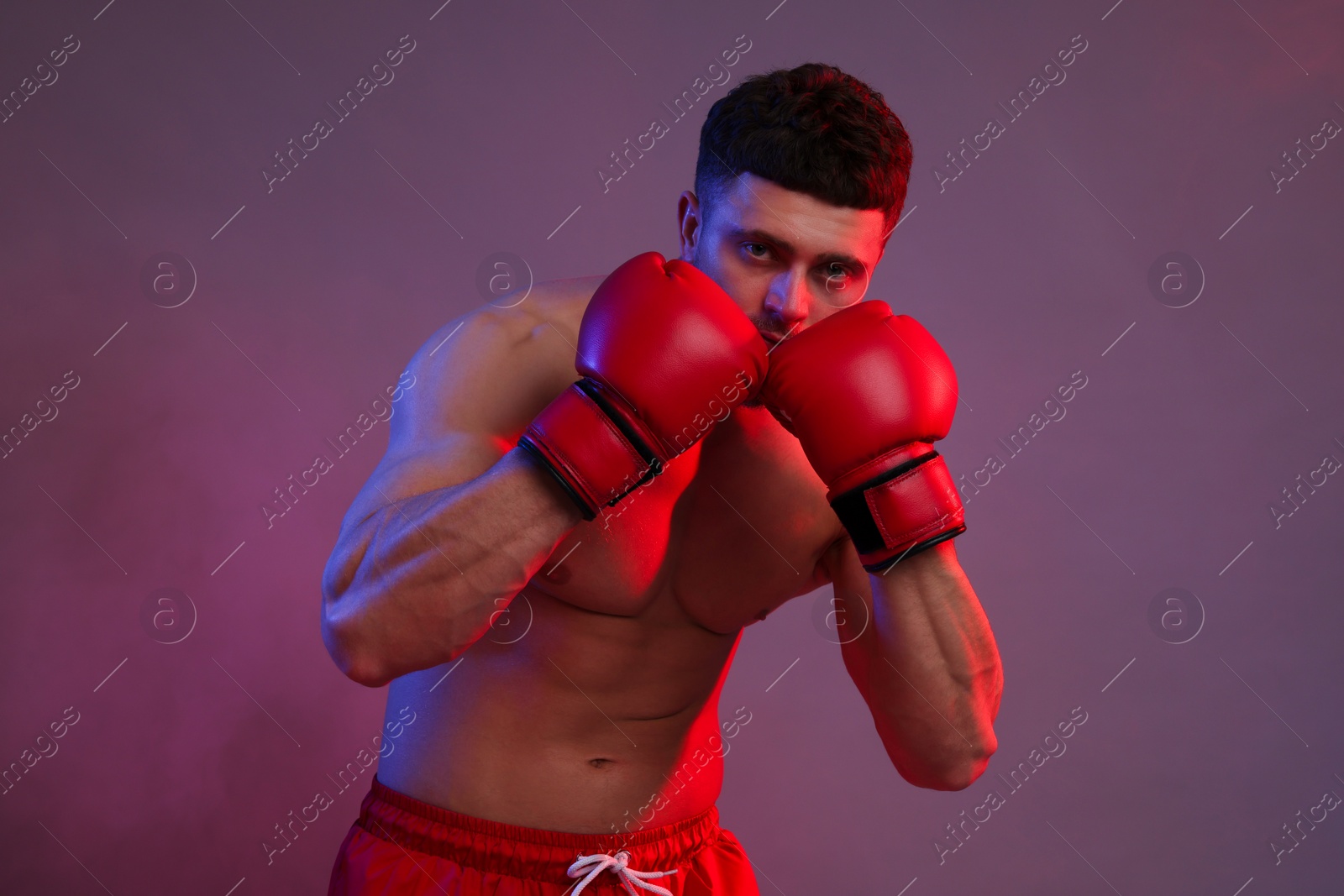 Photo of Man in boxing gloves on color background