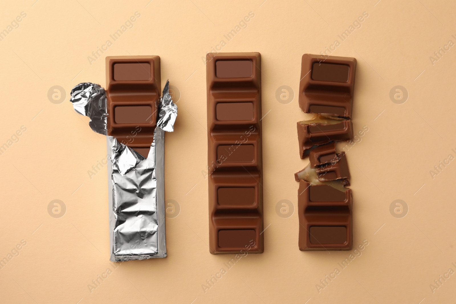 Photo of Delicious chocolate bars on beige background, flat lay