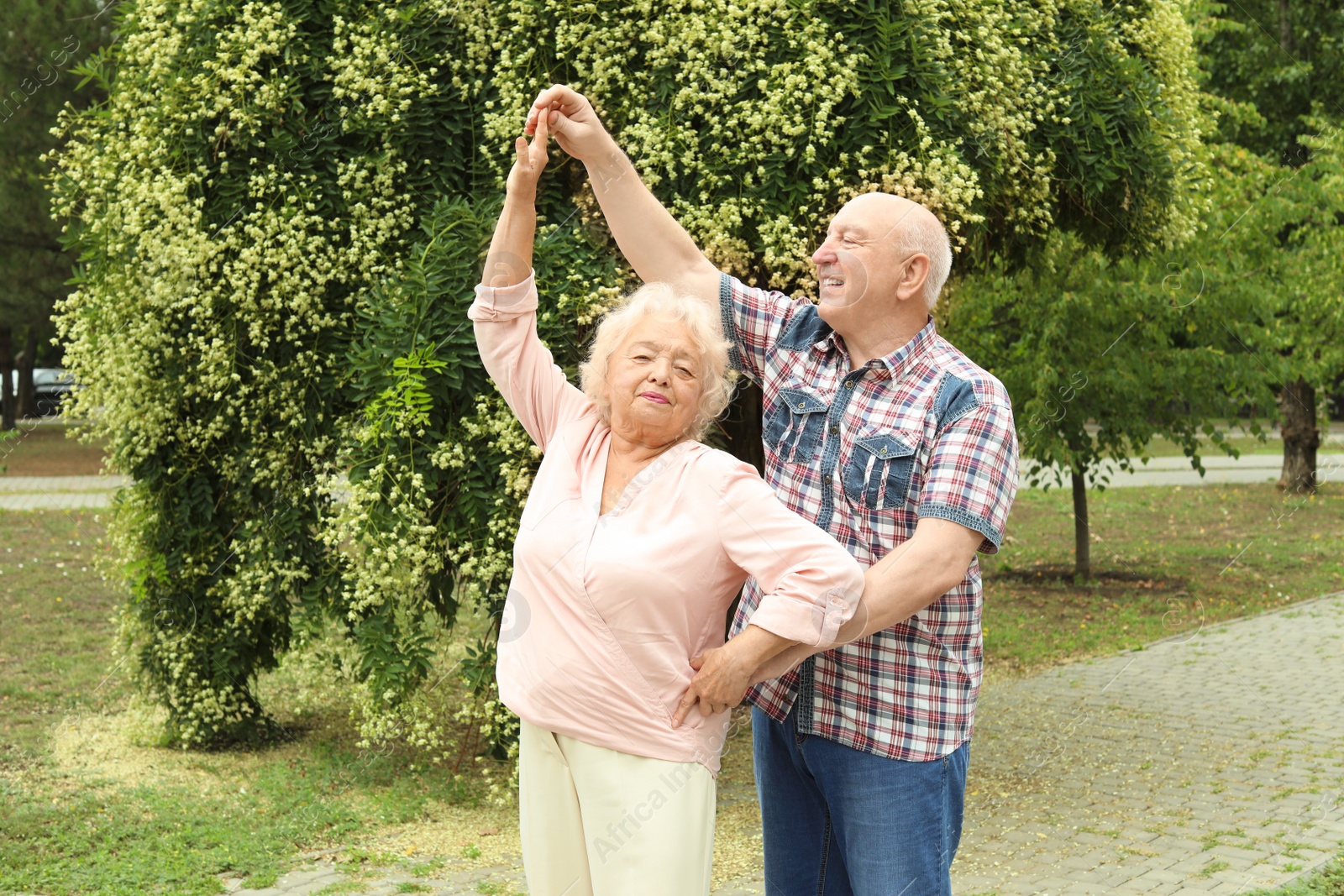 Photo of Cute elderly couple in love dancing outdoors