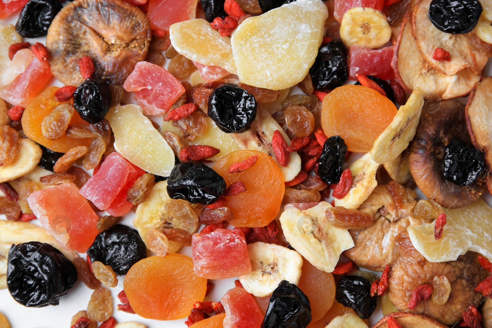 Photo of Pile of different tasty dried fruits on white background, top view