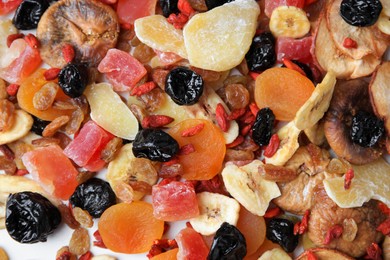 Pile of different tasty dried fruits on white background, top view