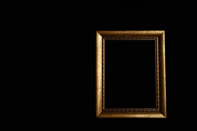 Photo of Empty golden frame on black background. Space for design