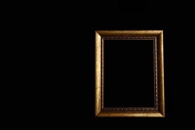 Empty golden frame on black background. Space for design