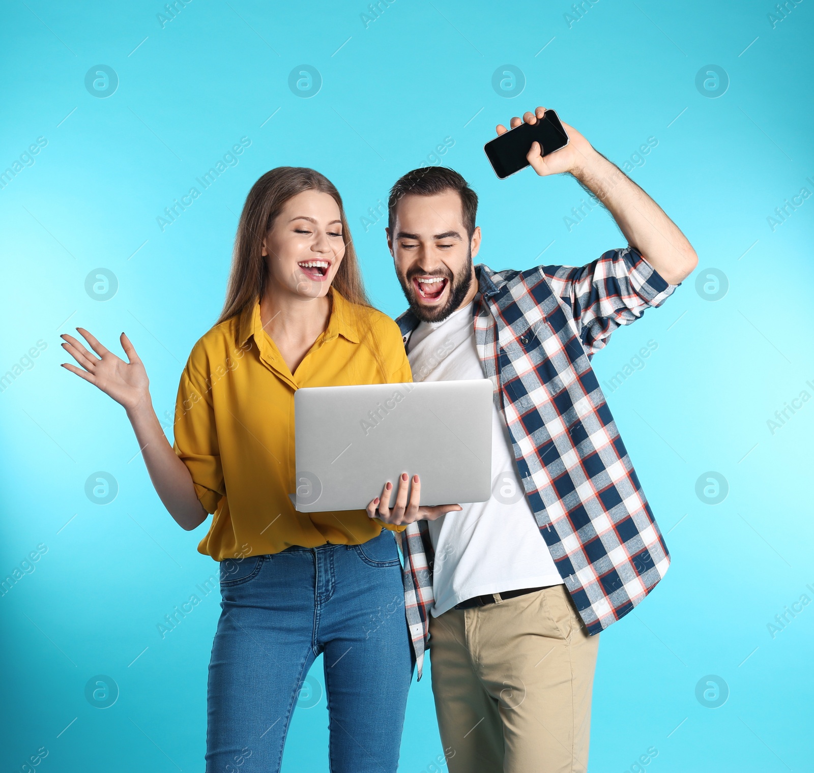 Photo of Emotional young people with laptop celebrating victory on color background