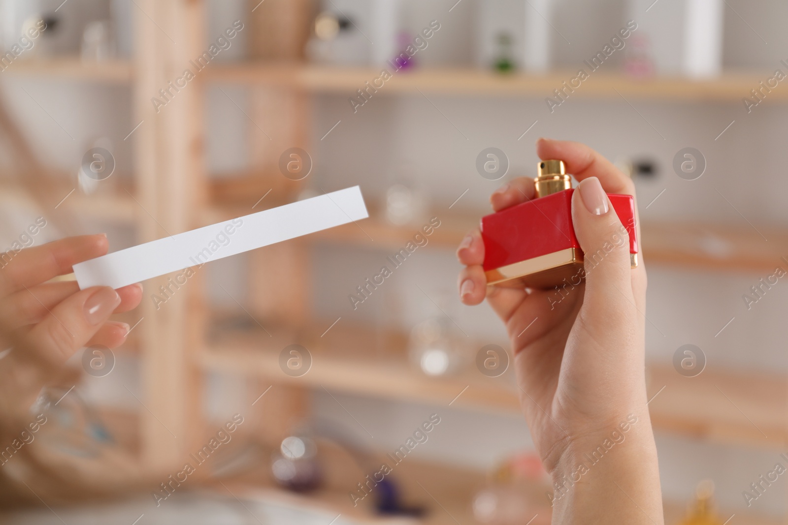 Photo of Woman with bottle of perfume and blotter indoors, closeup