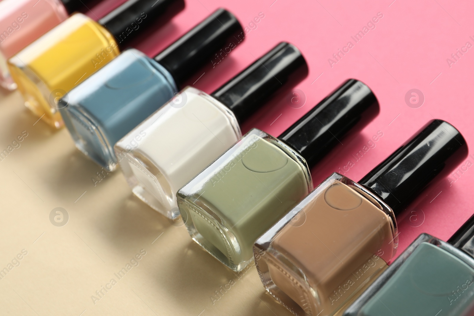 Photo of Beautiful nail polishes in bottles on color background, closeup