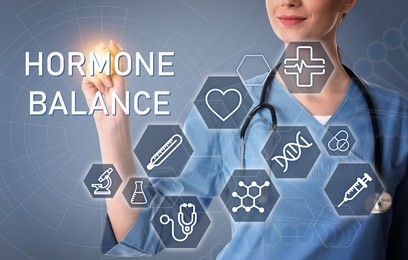 Doctor pointing at virtual screen with inscription Hormone Balance and digital icons on light grey background, closeup